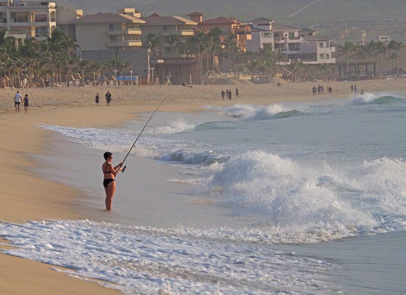A woman fishing in the surf